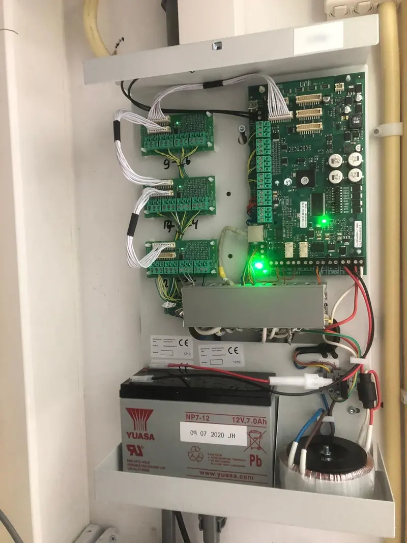 Geopende Alphatronics UNii-alarmcentrale met accu en aansluitingen
